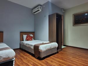 a hotel room with two beds and a tv at Hotel O Melody 88 Inn in Miri