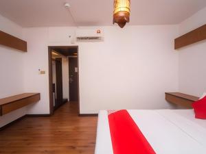 a bedroom with a white bed with a red blanket at Hotel O La Mirina Boutique Inn in Miri +41 photos