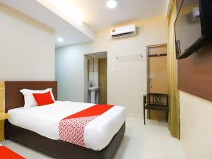 a hotel room with a bed and a bathroom at Hotel O La Mirina Boutique Inn in Miri