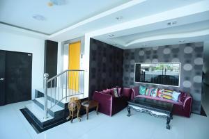 a living room with a purple couch and a staircase at Hotel O Astana Hotel in Tawau