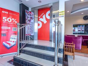 a lobby with a staircase and a purple chair at Hotel O Astana Hotel in Tawau