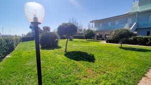 a street light in the grass near a building at Appartamento trilocale FRONTE MARE con SPIAGGIA INCLUSA Taunus vacanze cod 494 in Marcelli