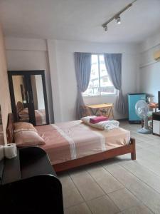a bedroom with a bed and a large window at OYO 75474 Funkey Fulung Andy & Tan Guest House in Pattaya Central
