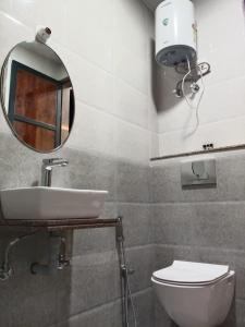 Un baño con lavabo, espejo e inodoro. en Hotel Mb Nirala Shyam, en Khātu