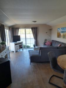 Area soggiorno di Chalet Makkum C99B met prive gelegen tuin aan het water
