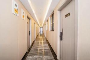 un corridoio vuoto di un ospedale con pareti bianche di 百灿青年客栈新国际博览中心店 a Shanghai