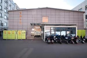 un gruppo di motocicli parcheggiato fuori da un edificio di 百灿青年客栈新国际博览中心店 a Shanghai