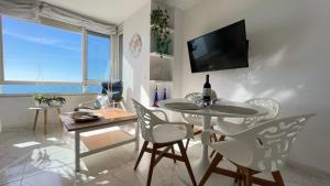 a living room with a table and chairs and a tv at Primera linea de playa en Torrox Costa in Torrox Costa