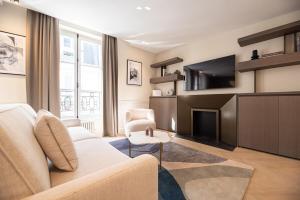 a living room with a couch and a tv at Relax in a Charming Flat in Le Marais in Paris