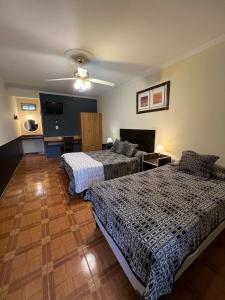 a room with two beds and a flat screen tv at Hotel Francia in San Rafael