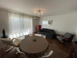 a living room with a table and chairs and a couch at Superbe appartement très spacieux en centre ville in Capbreton
