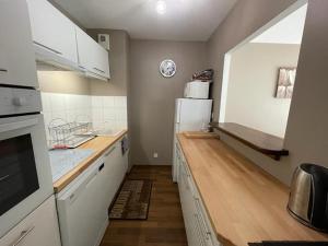 a kitchen with white cabinets and a white refrigerator at Superbe appartement très spacieux en centre ville in Capbreton
