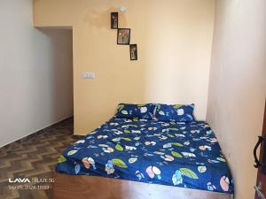 una piccola camera da letto con un letto con un piumone blu di The Kodai Fantasy a Kodaikānāl Altre 6 foto