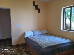 un piccolo letto in una stanza con una finestra di The Kodai Fantasy a Kodaikānāl