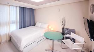 a bedroom with a bed and a table and a television at Daegu DSR Business Hotel in Daegu
