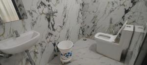 a dirty bathroom with a sink and a toilet at Hotel Touchwood in Prayagraj