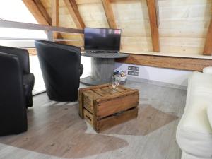 um quarto com uma mesa com um computador e cadeiras em Gîte autonome, La grange a foin, piscine ! em Bergholtz