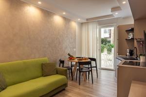 a living room with a green couch and a table at Vilu Suite Centro in Polignano a Mare