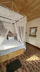 a bedroom with a bed with mosquito net at Mountain Shack Homestay in Ella