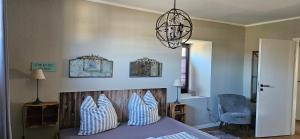 a bedroom with a bed and a chandelier at Haylees Hus 2 in Kellenhusen