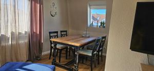 a dining room table with chairs and a window at Haylees Hus 2 in Kellenhusen
