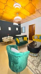 布瓦凯Residence d'Or Bouake的带绿色椅子和桌子的客厅 更多5张照片