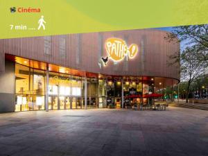 a large building with a sign on the side of it at Maison Cosy Centre Gare Amiens in Amiens