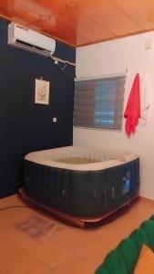 布瓦凯Residence d'Or Bouake的房间里有一张狗床，旁边还有一台风扇。