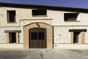 un edificio in mattoni con una porta e due finestre di Hotel Rural Alecook a Valcabado