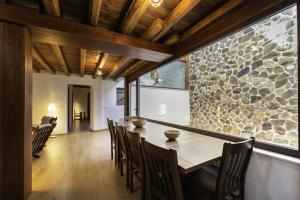 una sala da pranzo con un tavolo e un muro di pietra di Hotel Rural Alecook a Valcabado