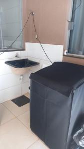 une salle de bain avec un lavabo noir et un miroir dans l'établissement Casa para Temporada da Tecnoshow, à Rio Verde