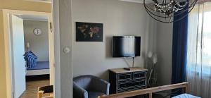 ein Wohnzimmer mit Fernseher und Sessel in der Unterkunft Haylees Hus in Kellenhusen