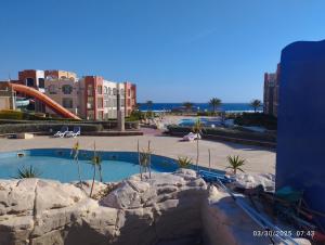 Marsa AlamOyster Bay Beach Suites k5-11的一座带游泳池和部分建筑的度假村