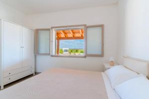 ナルドにあるMasseria Auletta Apartments - Salento Selectionのベッドと窓のある白い寝室