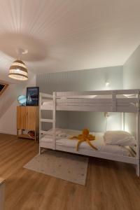 a bedroom with a bunk bed with an orange ribbon at TY KAER - Charmante maison neuve tout confort in Landunvez