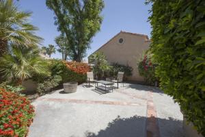 a patio with chairs and flowers and a building at Casitas Del Sol in Cathedral City