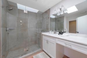 a bathroom with a shower and a sink and a mirror at Casitas Del Sol in Cathedral City +16 photos