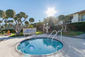 a swimming pool in a yard with the sun shining at Ranch Club Serenity in Palm Springs