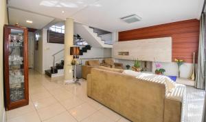 ein großes Wohnzimmer mit Sofas und einer Treppe in der Unterkunft Elegante Casa com Piscina - João Paulo - CEN006 in Florianópolis