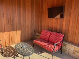 a red chair and a table and a television at Sundance Club Resort in Gordon