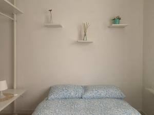a bedroom with a bed and two shelves on the wall at Cozy Piramide Rooms in Rome +9 photos