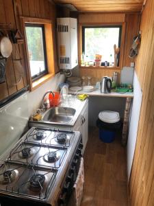 a kitchen with a stove and a sink at Hostal Huepil in Pucón