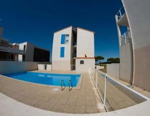 une maison avec une piscine à côté d'un bâtiment dans l'établissement Appartement avec piscine et accès direct à la mer, à Châtelaillon-Plage