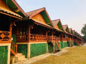 a building with green and brown at Bungalows Le Jardin VANGVIENG in Vang Vieng