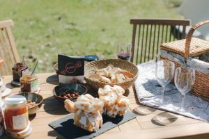 a table with food and wine glasses and a basket of food at WilderCamp in Almeida
