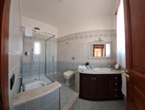 a bathroom with a tub and a sink and a toilet at Mariposa B&B in San Vito lo Capo