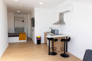 a kitchen with a counter and two bar stools at Carthago Suites - Puerto in Cartagena