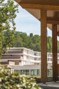 un edificio bianco con alberi sullo sfondo di Hôtel des Thermes des Fumades ad Allegre Les Fumades