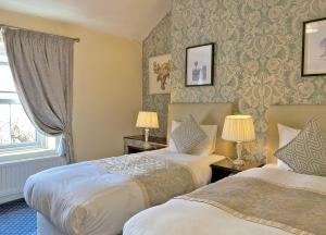 a hotel room with two beds and a window at Fitzwilliam Townhouse in Dublin
