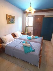 two beds in a room with towels on them at Blue Dolphins 2 bedroomed house with court yard in Skiathos Town